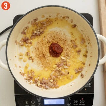 Sauteing garlic and tomato paste with shallots.