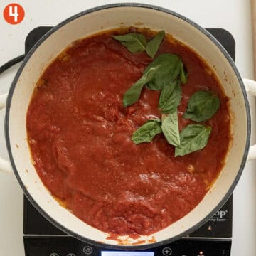 Simmering crushed tomatoes, basil and salt.
