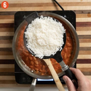 Boiled rice drained in a mesh strainer.