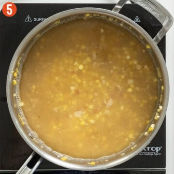 Chicken stock simmering with orzo.