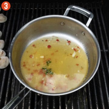 White wine sauce in a saucepan on the grill.