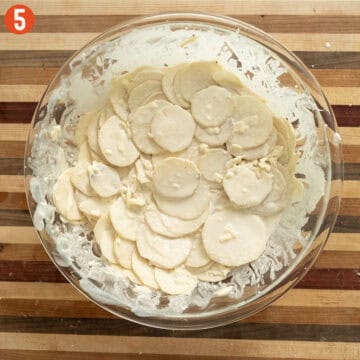 Combining potatoes, cheese, and heavy cream in a large bowl.