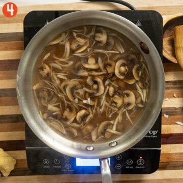 Simmering mushrooms and shallots in stock and marsala wine.