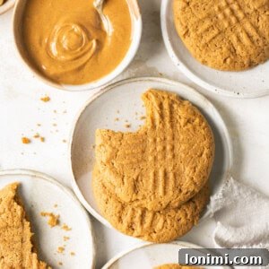 Mary's Signature Gluten-Free Peanut Butter Cookies 8 gluten free peanut butter cookies on small white plates with a bowl of creamy peanut butter and a white napkin