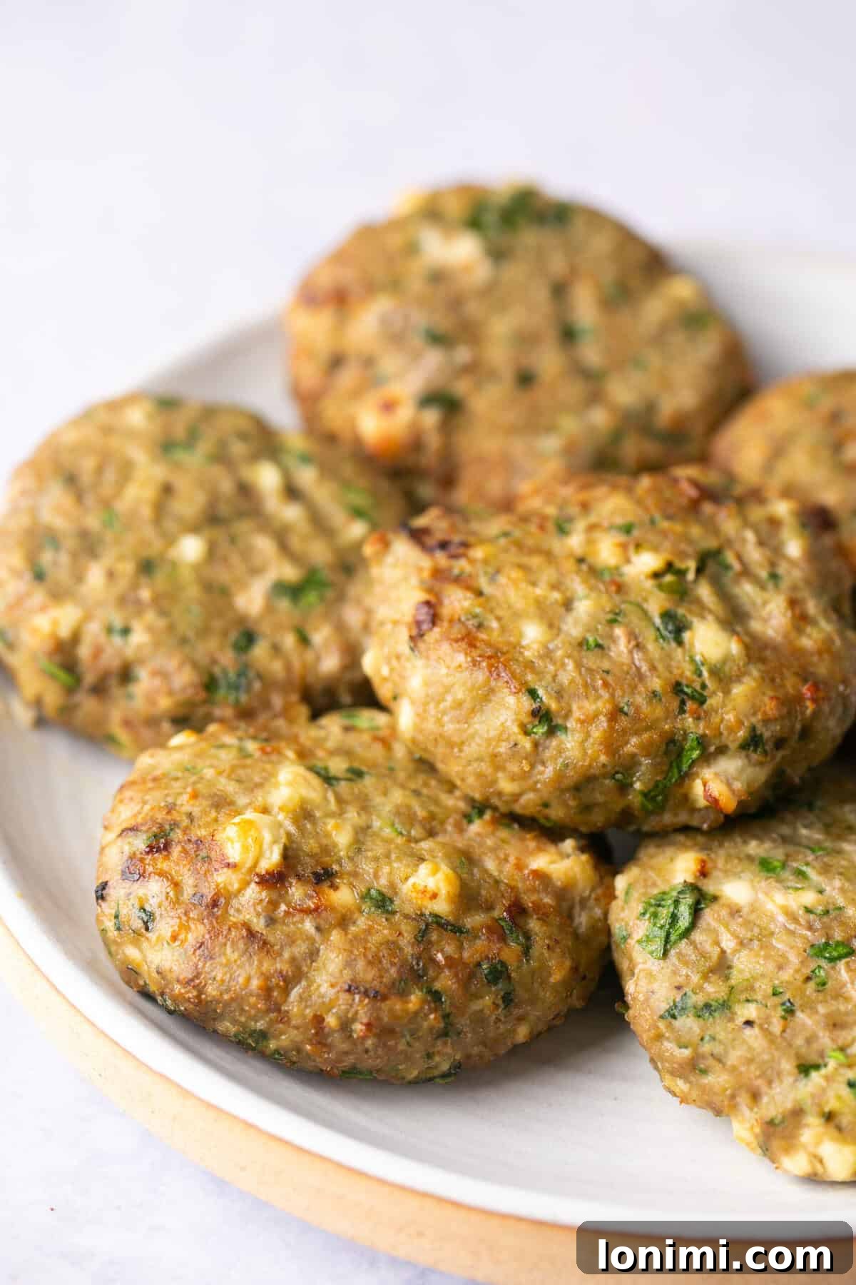 Flavorful Air-Fried Turkey Burgers with Spinach and Feta 5 Cooked air fryer turkey burger patties arranged on a plate, ready to be served or dressed with toppings.
