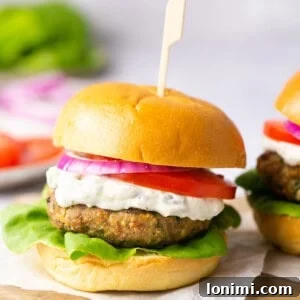 Flavorful Air-Fried Turkey Burgers with Spinach and Feta 7 A turkey burger on a gluten-free bun with tzatziki sauce, tomato, lettuce, and red onion