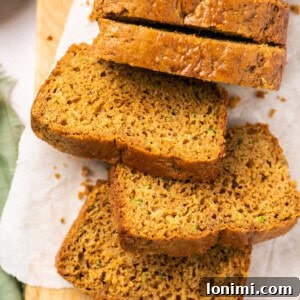 Gluten-free zucchini bread sliced on a cutting board with parchment paper.