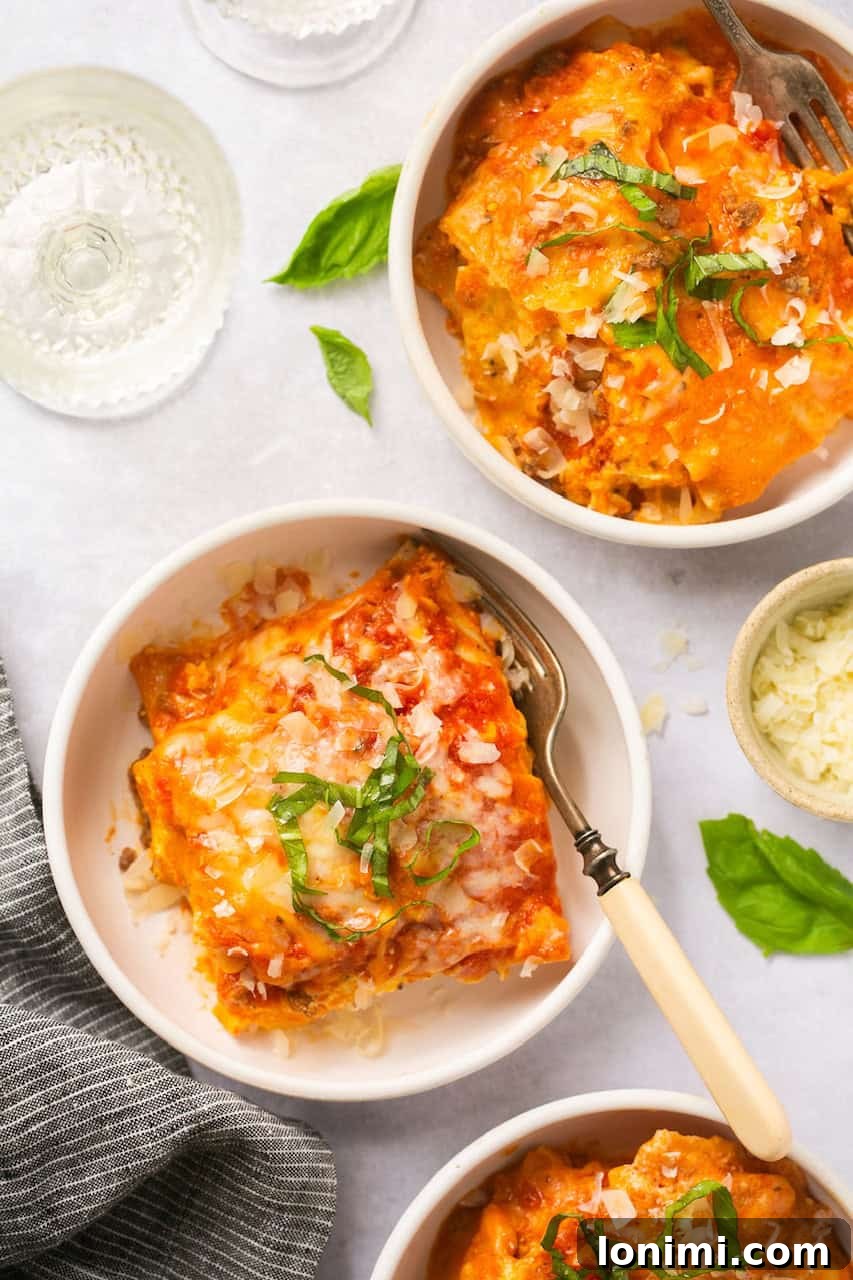 an overhead shot of three white bowls filled with slices of lasagna with gluten free noodles
