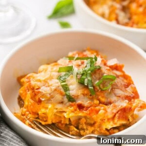 Instant Pot Lasagna in a white bowl topped with basil with a fork