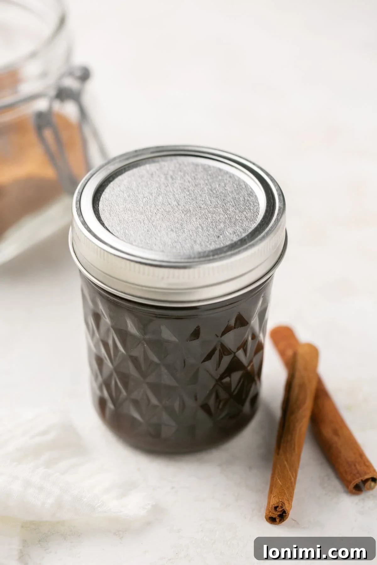 A close-up of amber brown sugar syrup in a mason jar with a silver lid, ready for storage in the refrigerator.