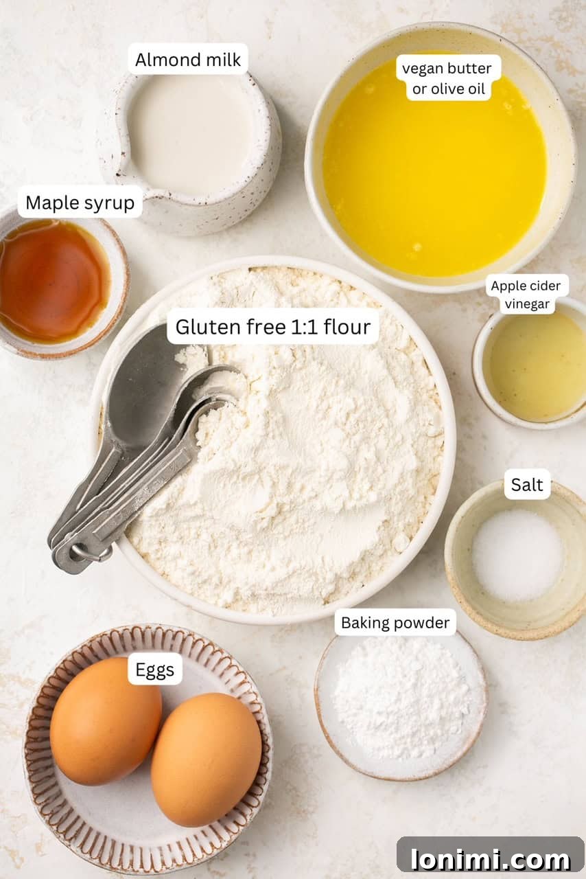individual ingredients for dairy free biscuits, including gluten-free flour, almond milk, eggs, and butter, neatly arranged on a photography backdrop