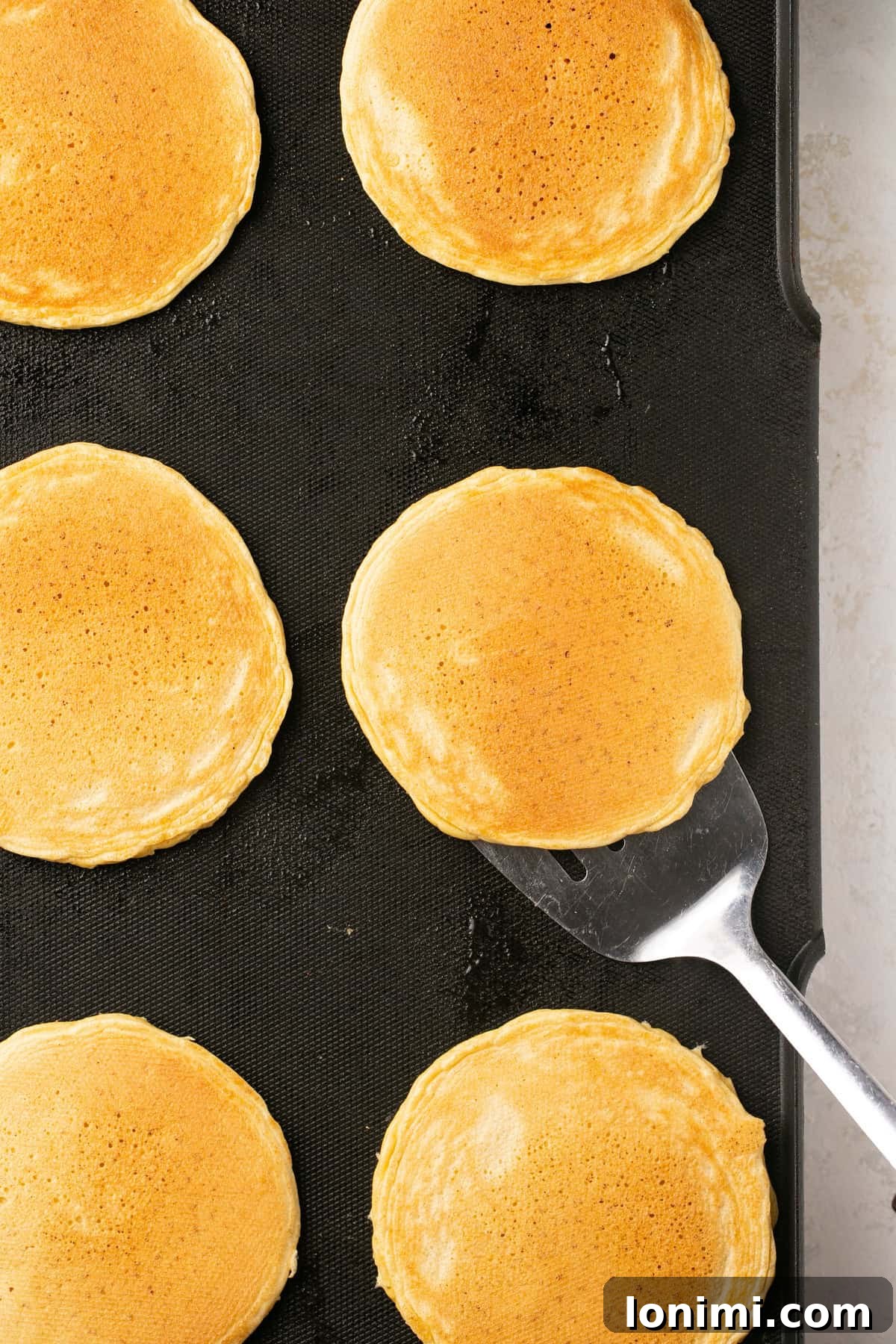 pancakes being flipped on a griddle