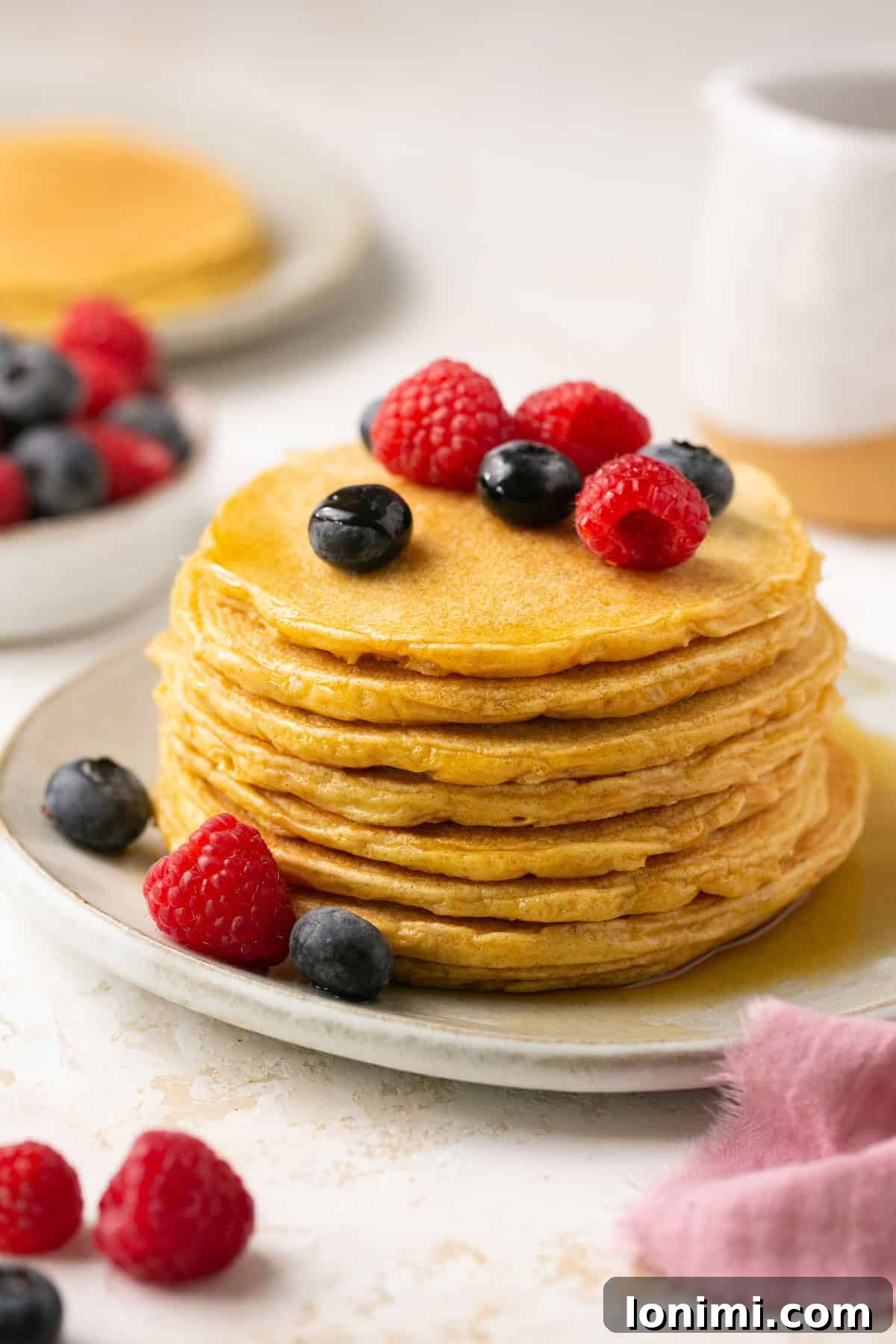 protein pancakes stacked on a plate with berries