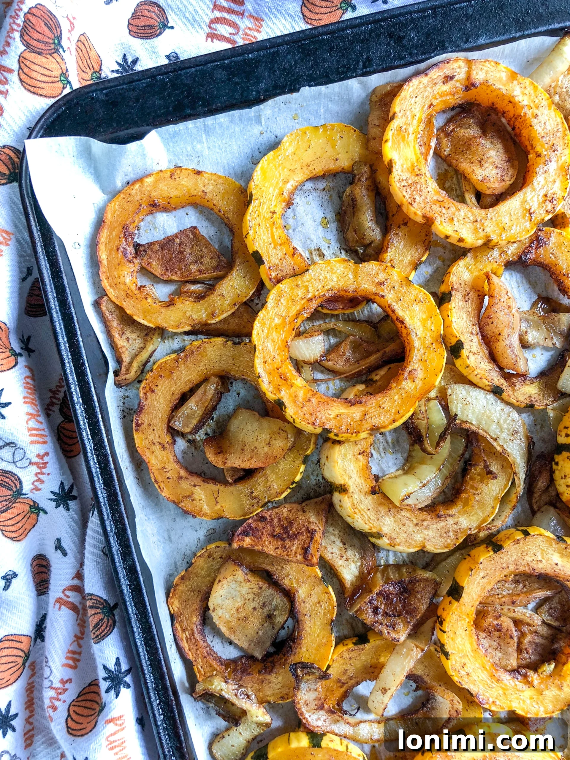 Sweet and Spicy Delicata Squash with Apples and Onions 2 Roasted Delicata Squash, Apples, and Onions on a baking sheet, fresh out of the oven.