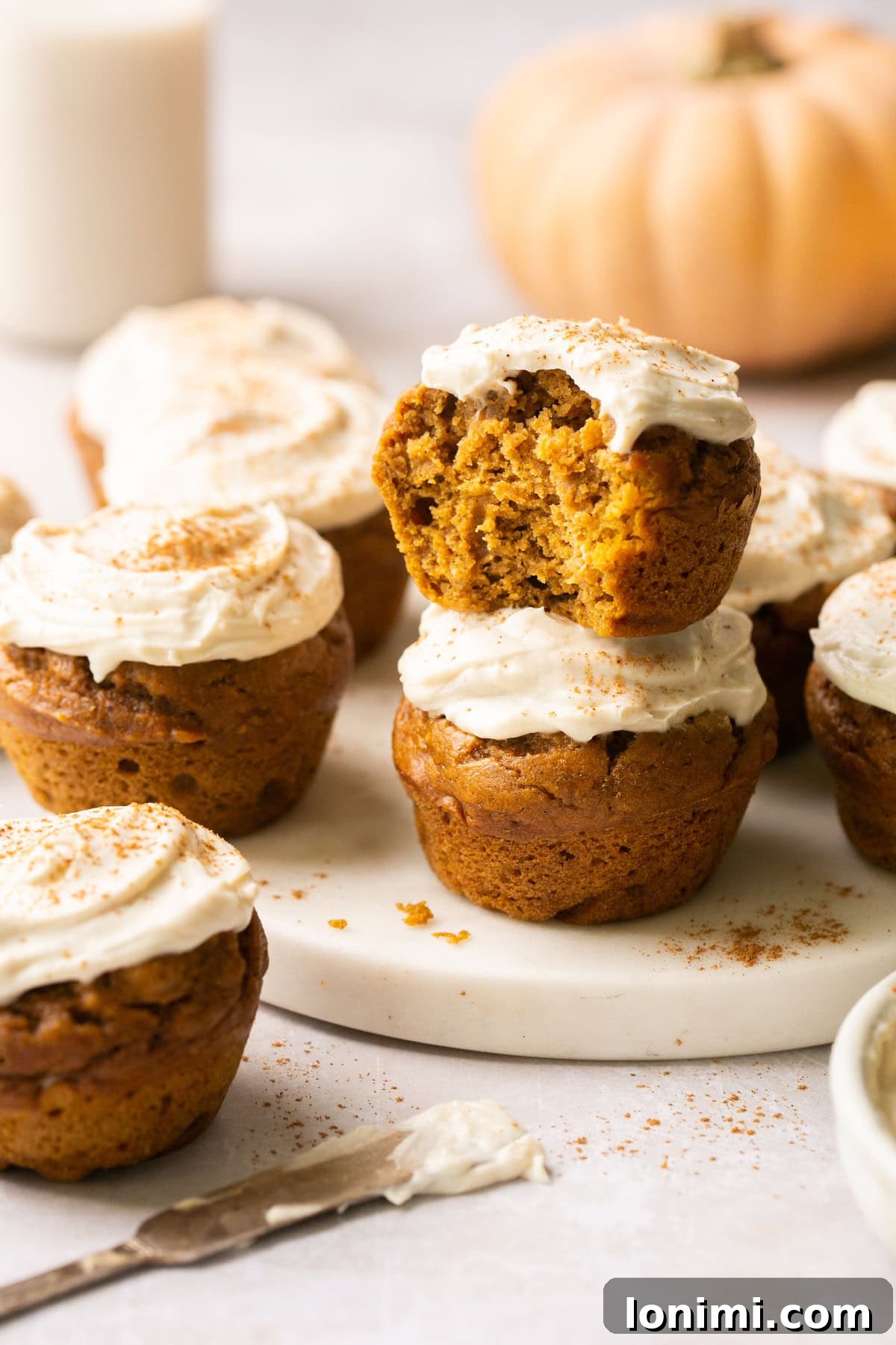 Simple Pumpkin Muffins with Velvety Dairy-Free Cream Cheese Frosting 2 A closeup photo of fluffy gluten-free pumpkin muffins topped with creamy dairy-free frosting, ready to be enjoyed.