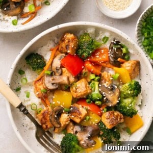 salmon stir fry in a bowl over white rice