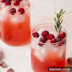 Mistletoe Martini with vodka and cranberry juice, topped with cranberries and rosemary