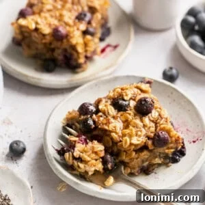 Protein-Packed Vegan Baked Oats 9 vegan baked oats on a plate with a gold fork taking a bite out