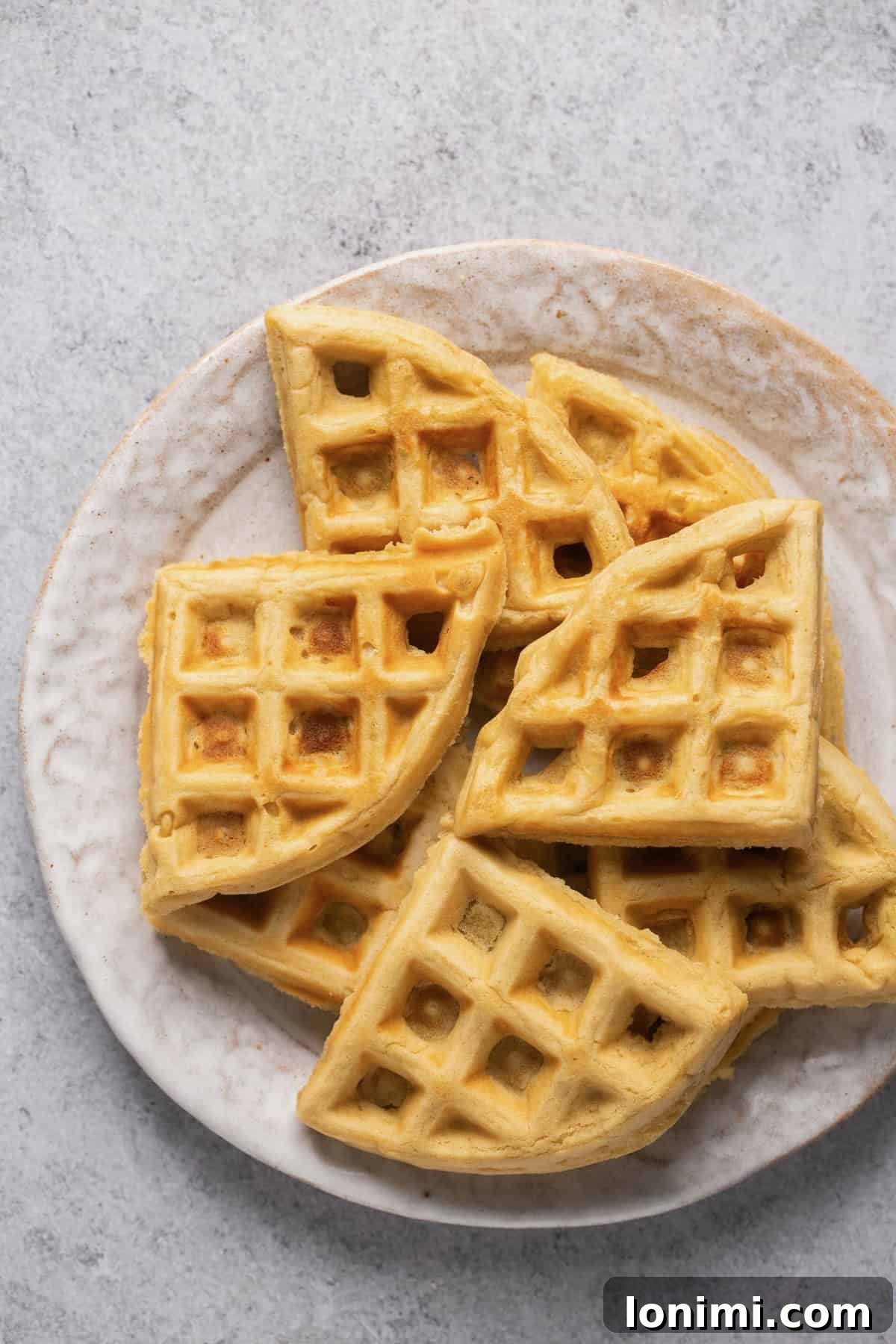 Wholesome and Delicious Gluten-Free Dairy-Free Waffles 5 waffle triangles stacked on a white plate