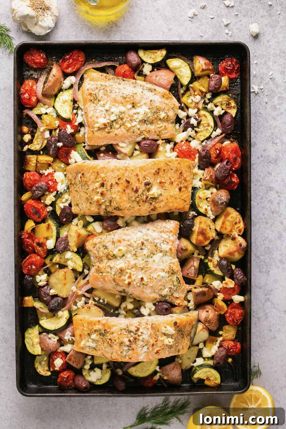 Sheet pan salmon and vegetables with Greek Marinade and feta, fresh out of the oven on a sheet pan.