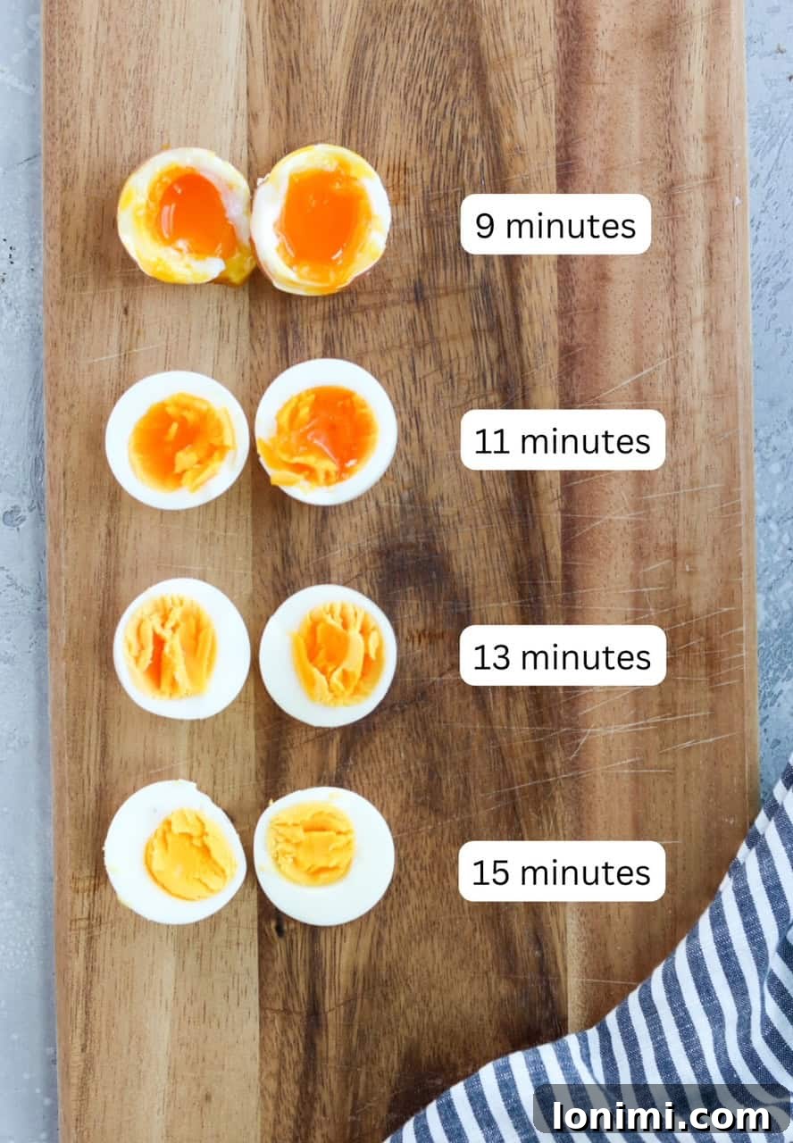 A wooden cutting board displaying air-fried eggs sliced in half, demonstrating different cooking times for various yolk consistencies.