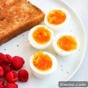 air fryer soft boiled eggs on a plate with toast and raspberries