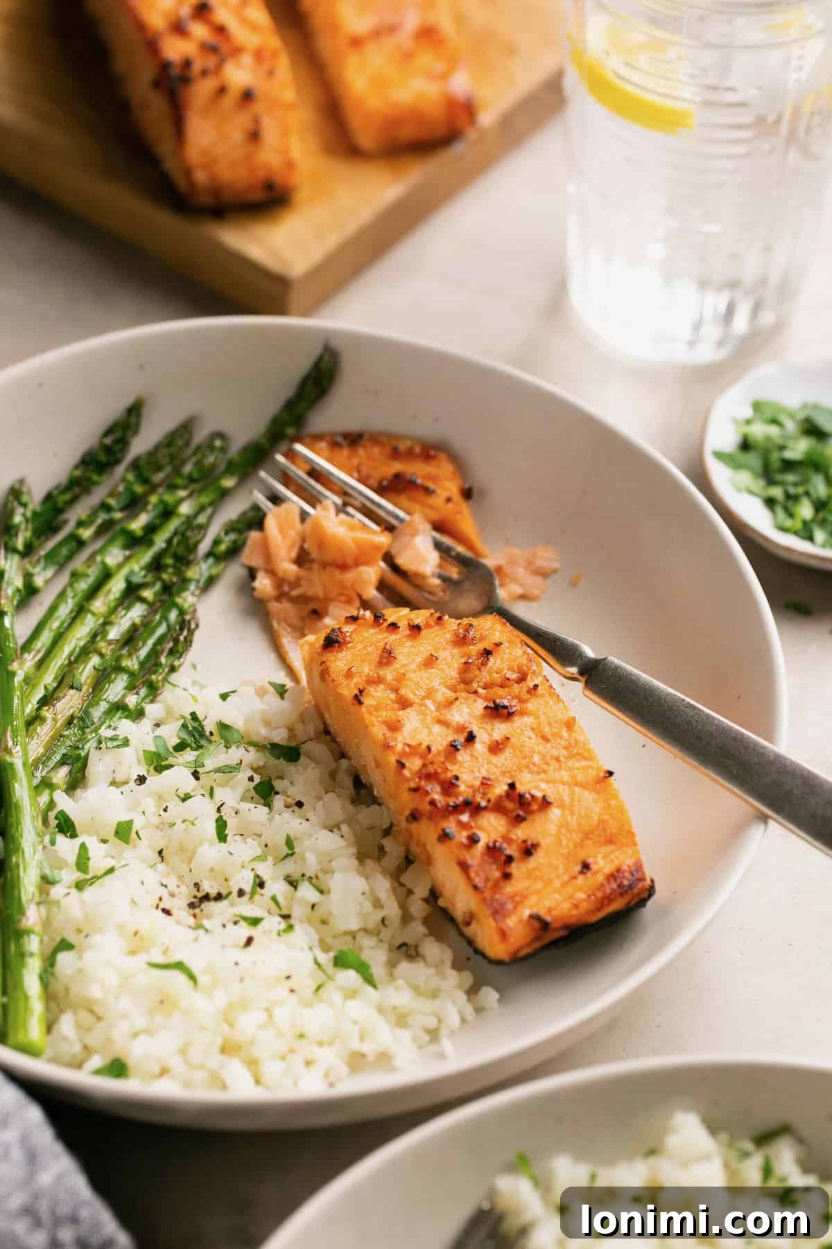 a fork cutting a bite of flaky salmon. 