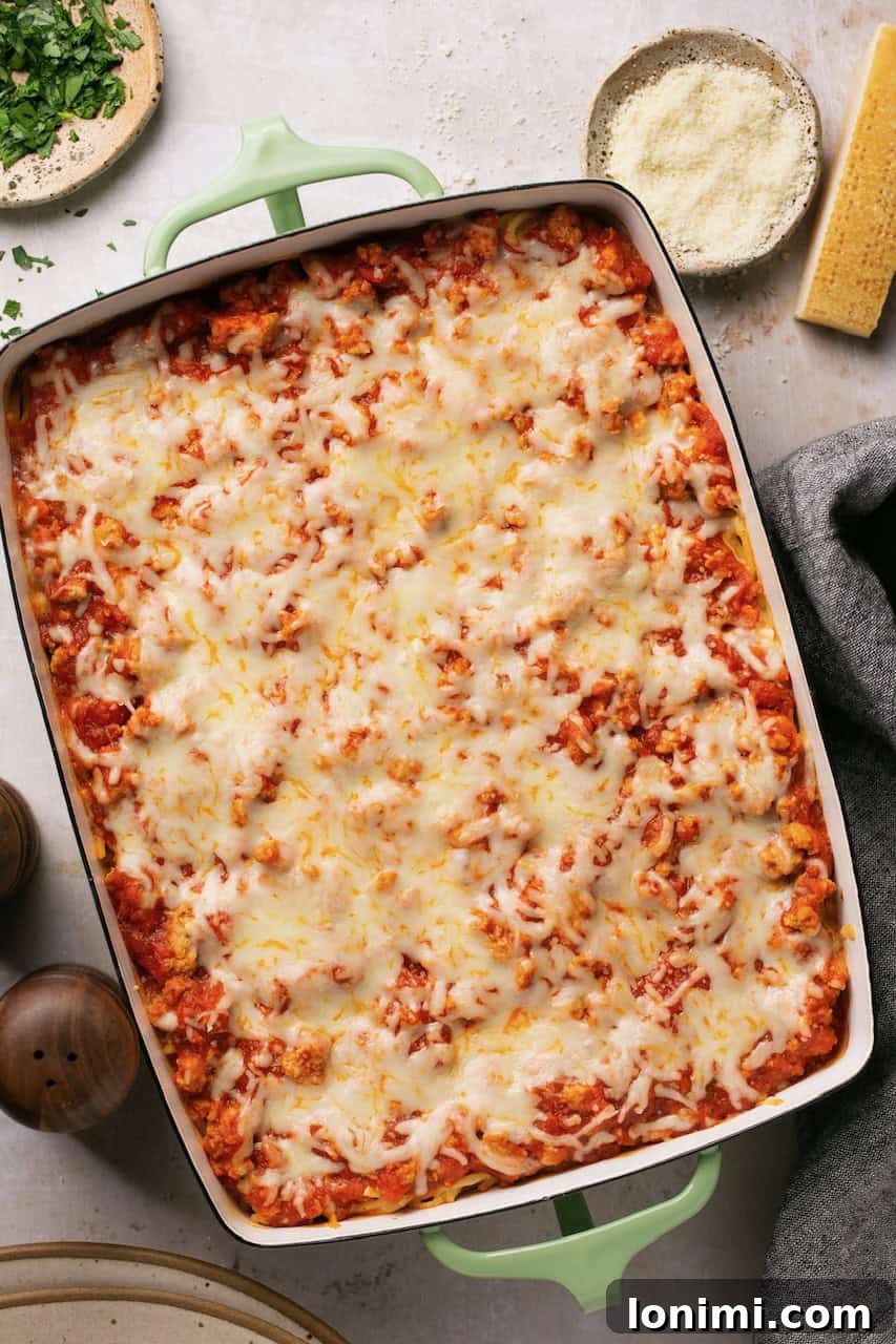 An overhead shot of a baked spaghetti alfredo casserole, freshly out of the oven, with melted and bubbling cheese.