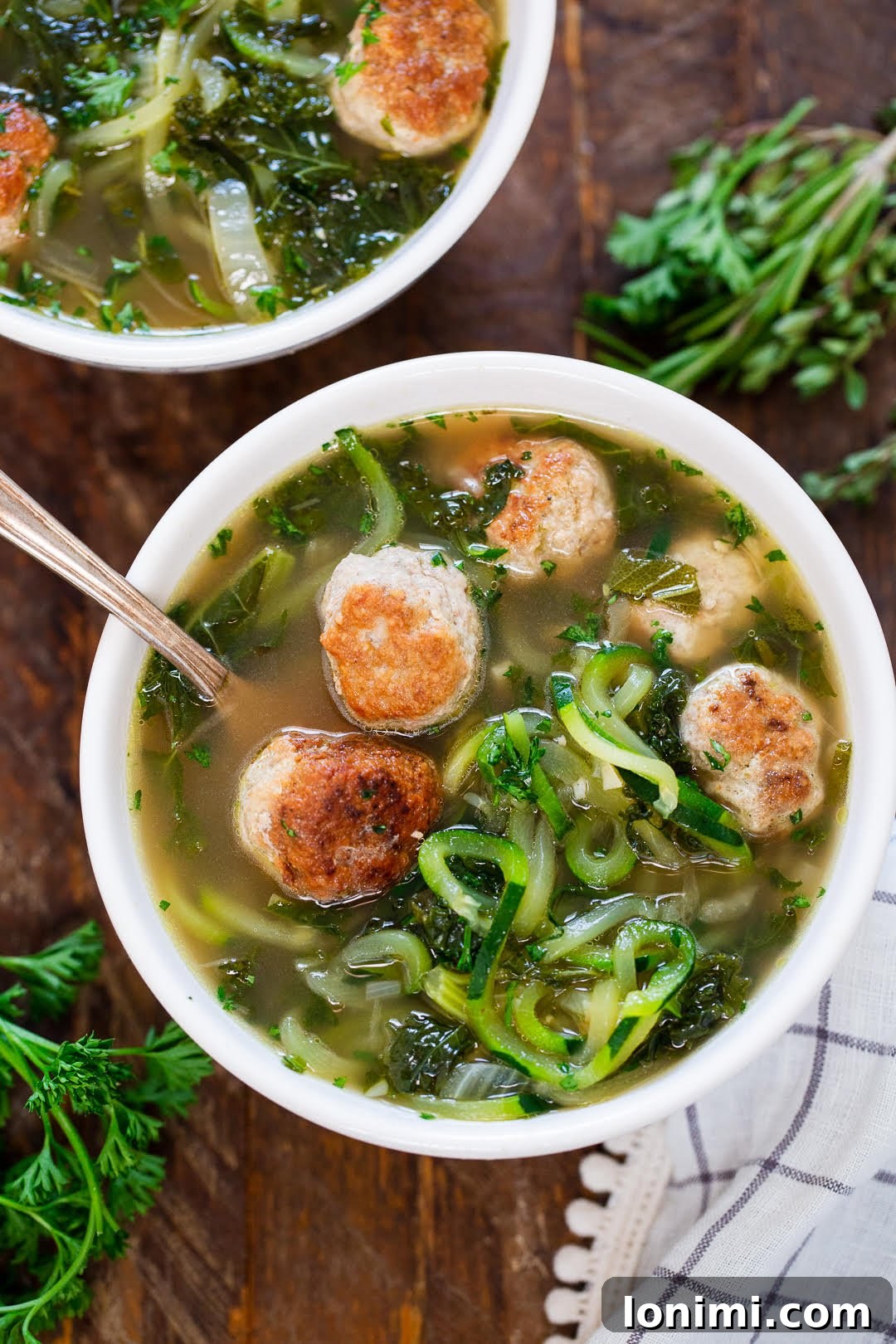 Hearty bowl of Paleo Turkey Meatball and Zoodle Soup, with tender meatballs and spiralized zucchini noodles.