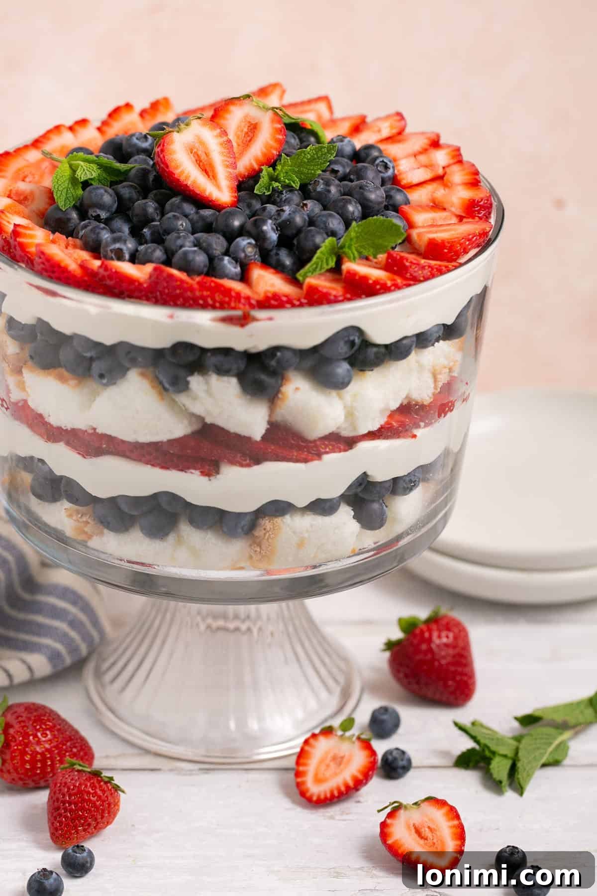 Heavenly Gluten-Free Strawberry Angel Food Trifle 2 Vibrant berry angel food trifle with fresh mint leaves in a clear glass bowl, showcasing layers of cake, berries, and creamy topping. Ideal for summer gatherings.