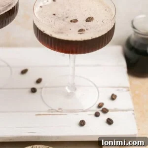 espresso martini on a palate board with espresso beans around it