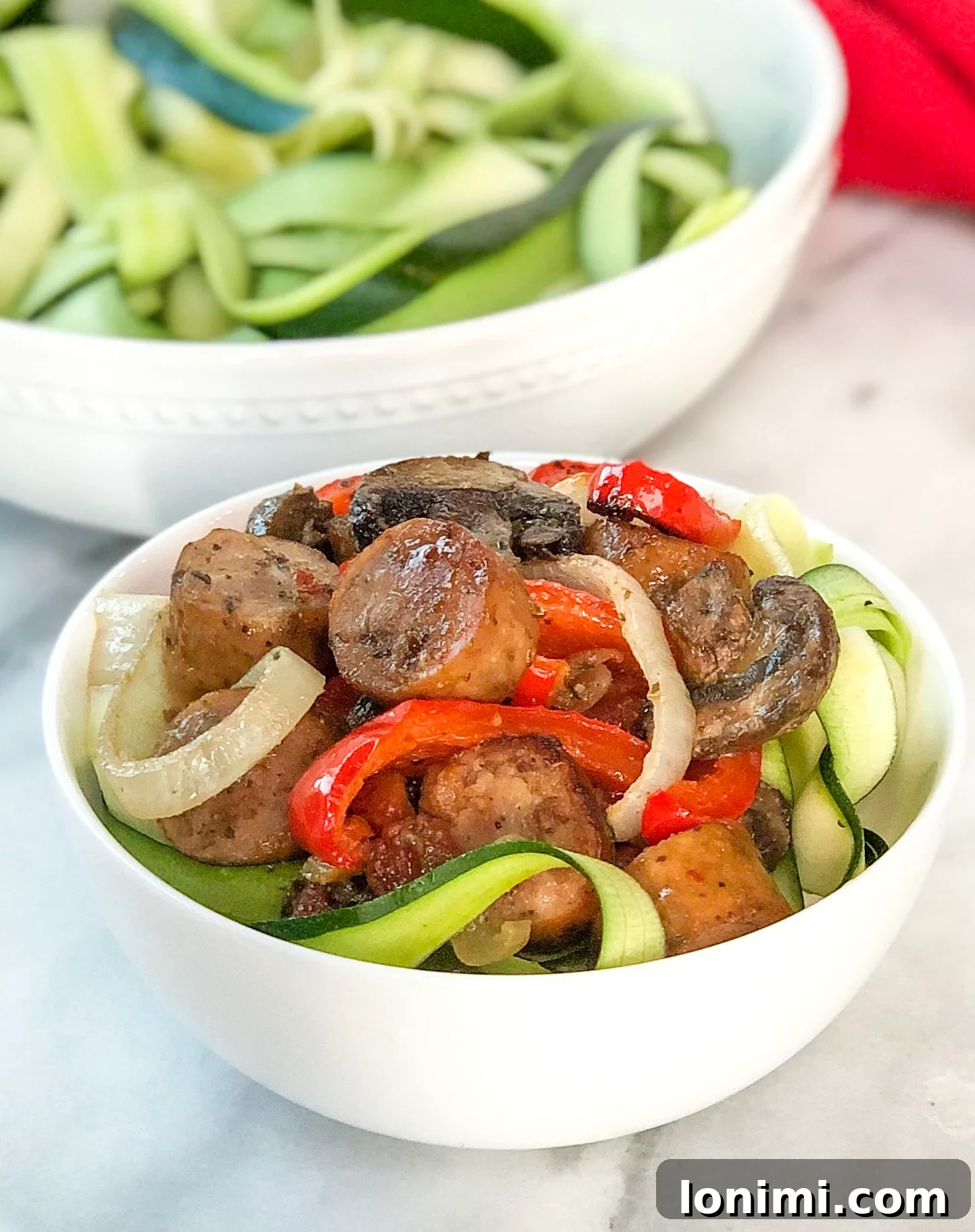 Plated Sheet Pan Italian Sausage and Peppers with zucchini ribbons