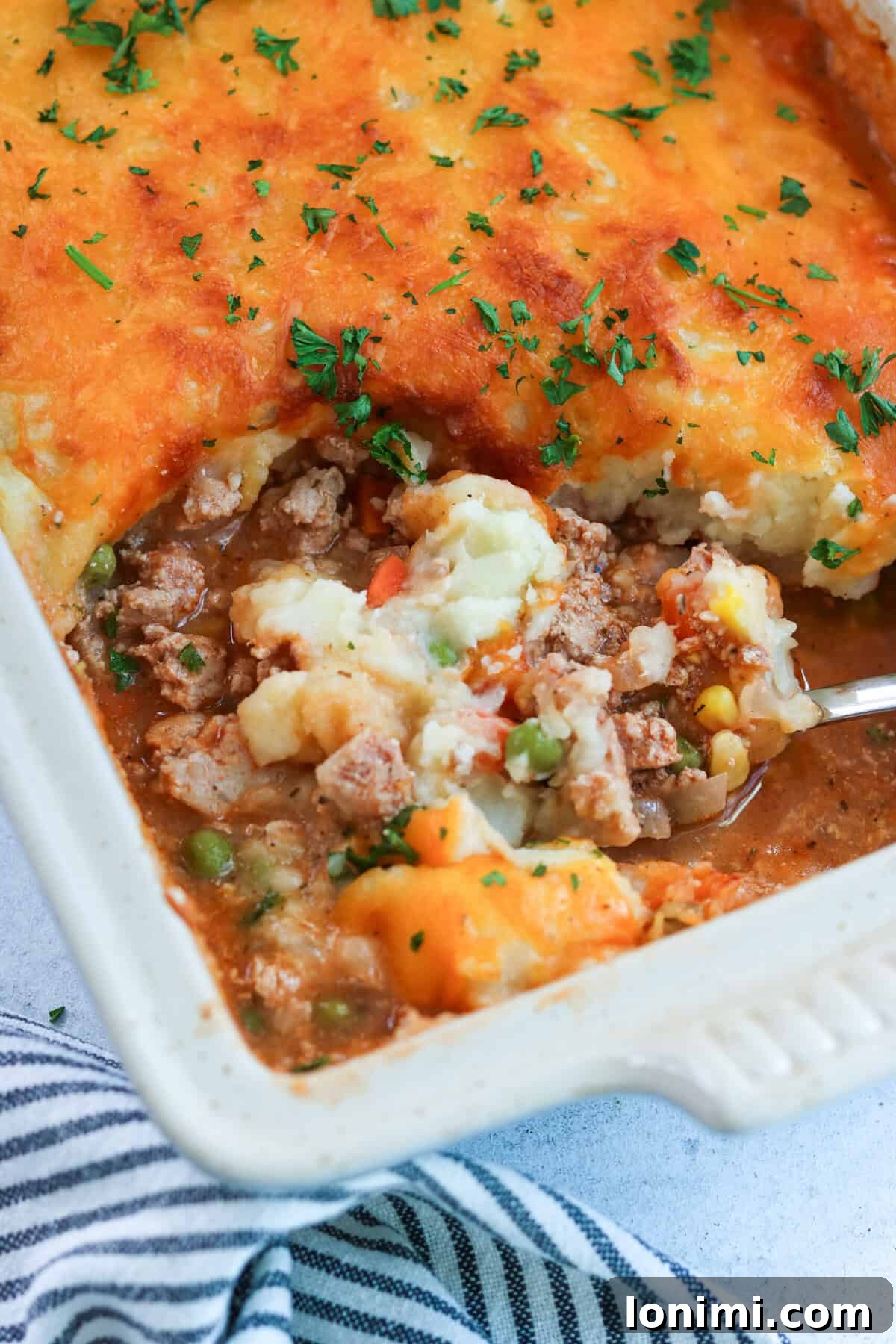 ground turkey shepherd's pie in a casserole dish with a scoop being taken out