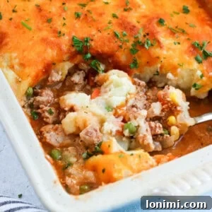 ground turkey shepherd's pie in a casserole dish with a scoop being taken out