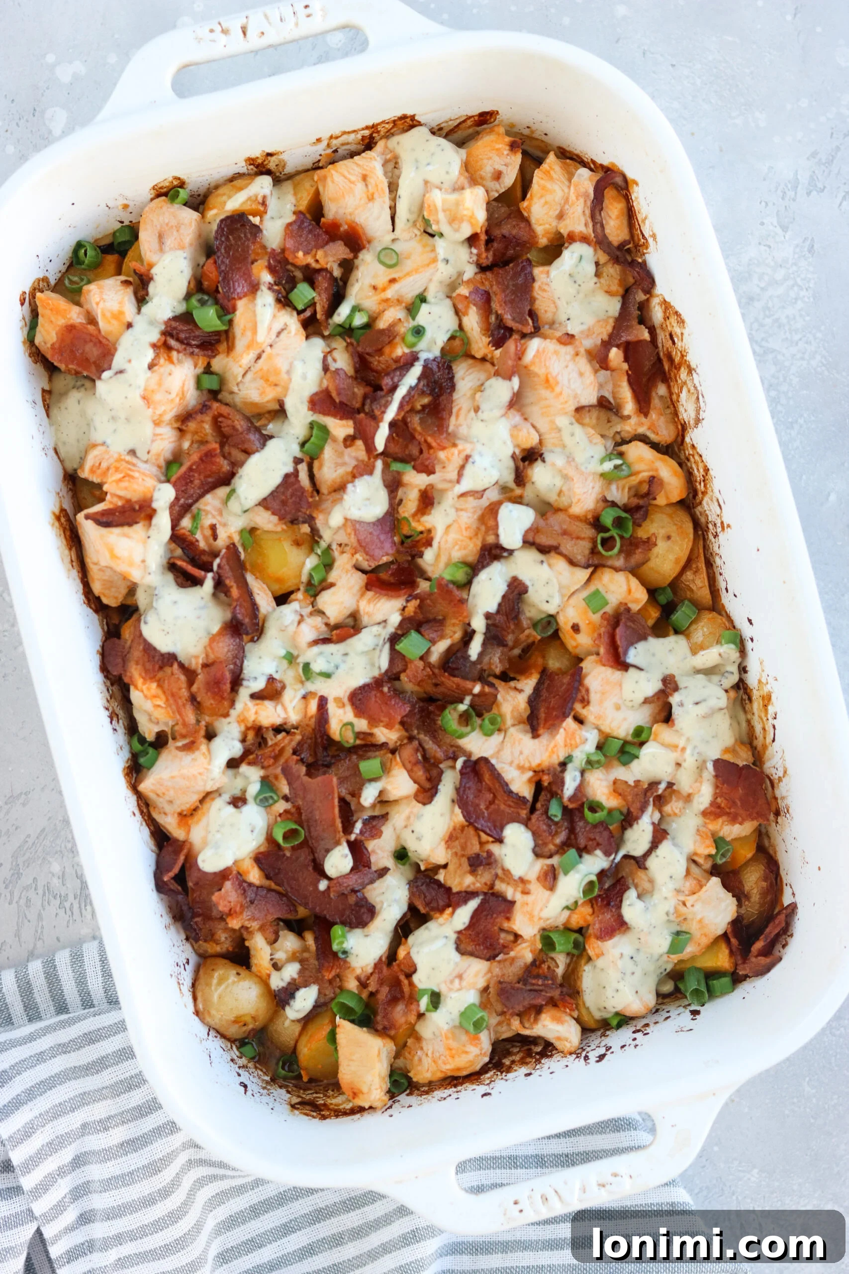 Healthy Whole30 buffalo chicken casserole with a generous drizzle of compliant ranch