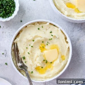 Gluten-free mashed potatoes in two bowls with chives and butter