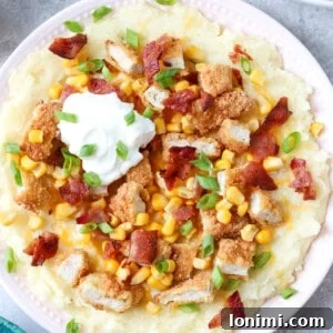 Ultimate Mashed Potato Bowls 9 gluten free loaded potato bowl with mashed potatoes, cheese, bacon, corn, chicken tenders, bacon, and green onions with a dollop of sour cream