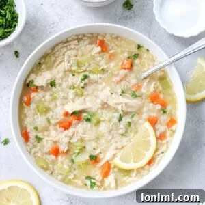 gluten free chicken noodle soup made with pastina in a bowl topped with parsley and parmesan
