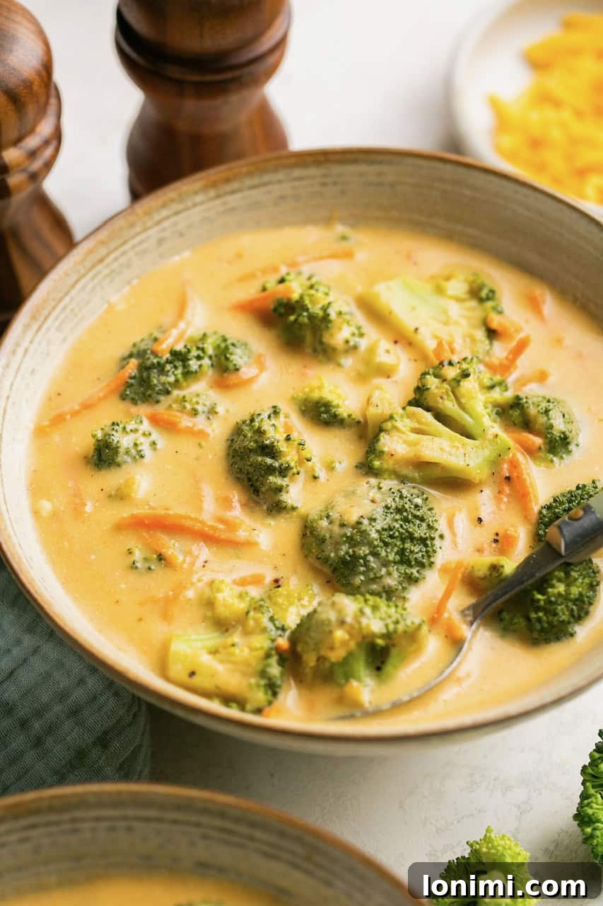 Instant pot broccoli cheddar soup in a bowl with salt and pepper shakers behind it 