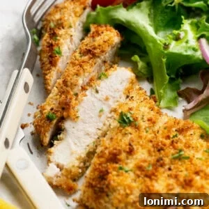 sliced air fryer chicken cutlet on a plate with salad