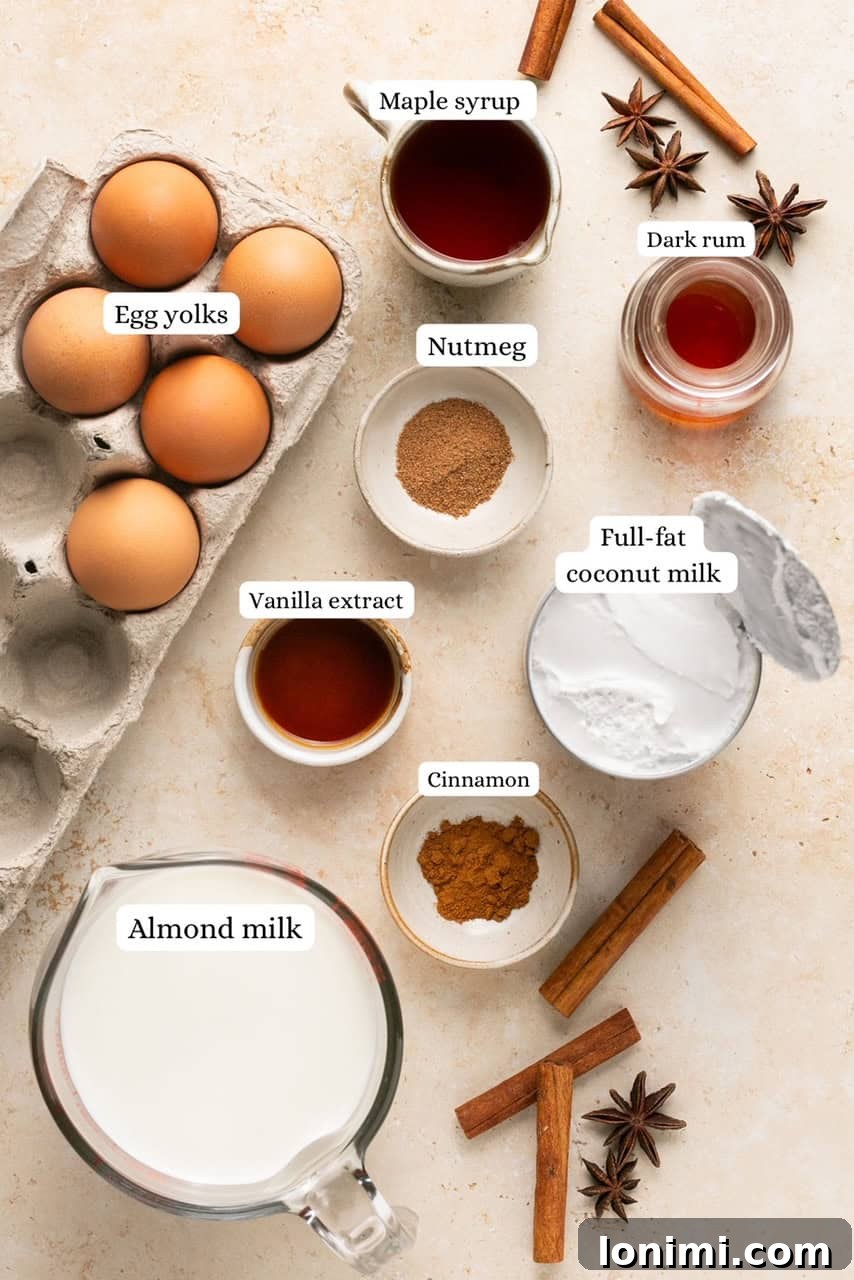 Fresh ingredients laid out for making dairy-free eggnog, including coconut milk, almond milk, eggs, and spices.