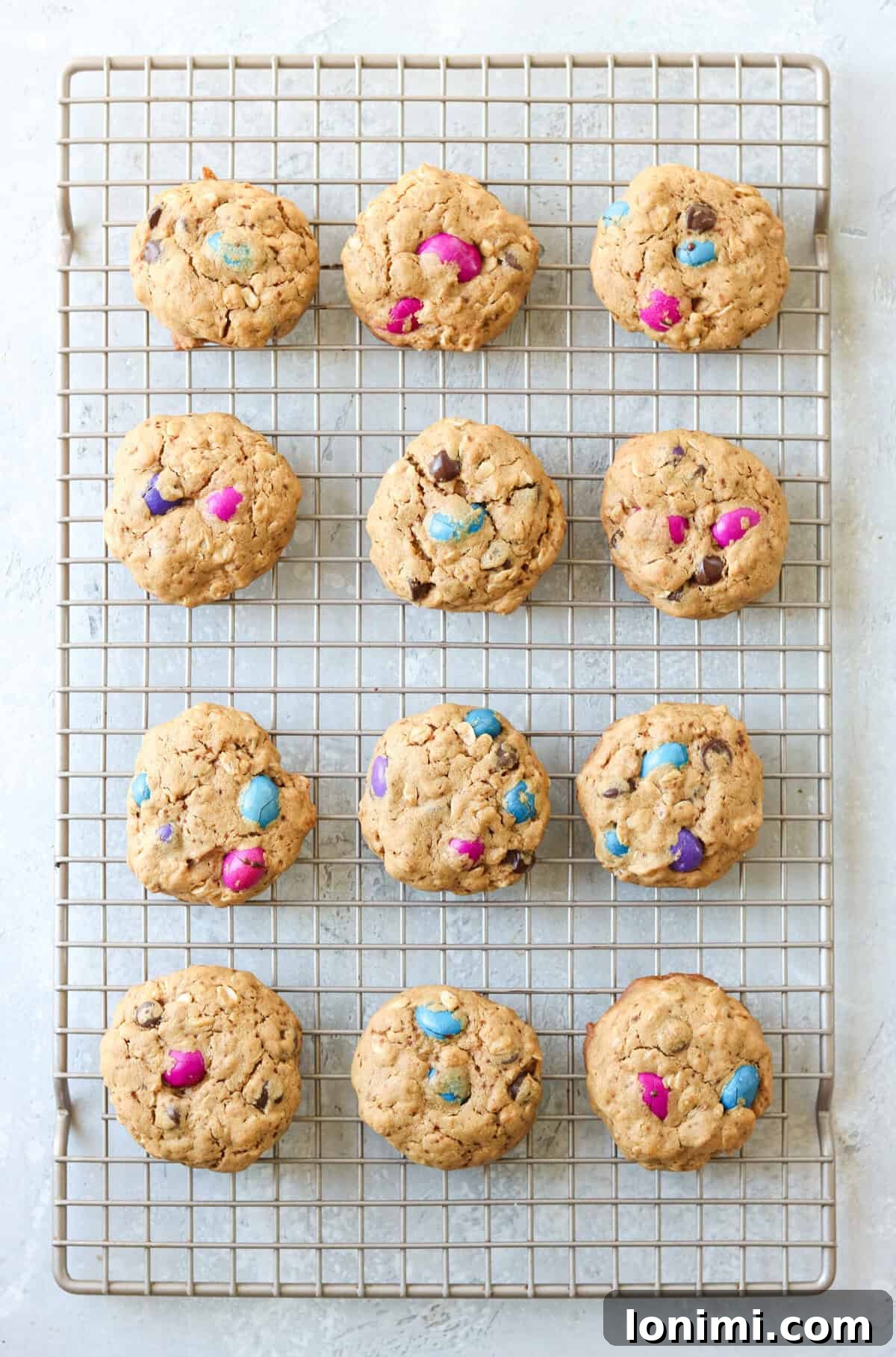 Freshly baked gluten free monster cookies cooling on a wire rack, showcasing their rich texture and colorful candy inclusions.