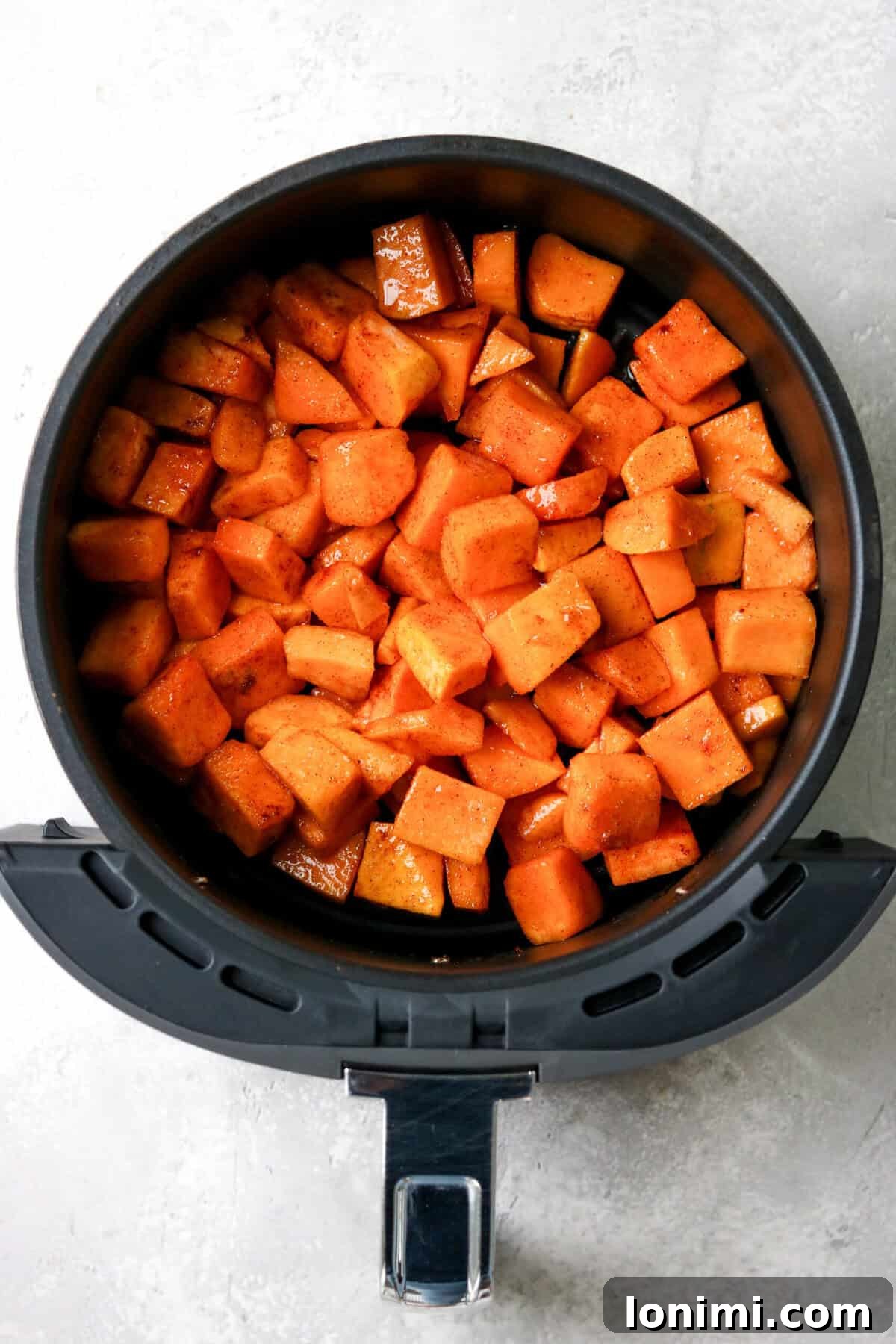 uncooked butternut squash cubes in an air fryer 