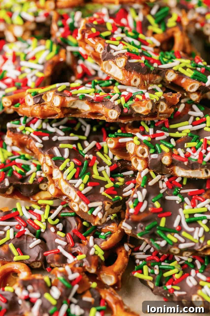 Addictive Gluten-Free Holiday Pretzel Bark 9 A wide shot of a tray of completed pretzel Christmas crack, beautifully spread out on parchment paper, awaiting to be broken into pieces.