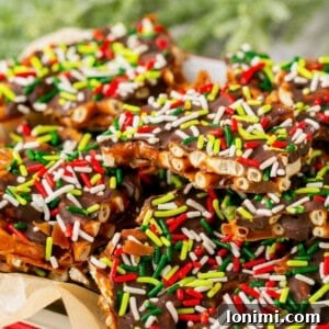 Addictive Gluten-Free Holiday Pretzel Bark 10 Pretzel Christmas Crack on a plate with parchment paper, showcasing its appealing textures and layers.