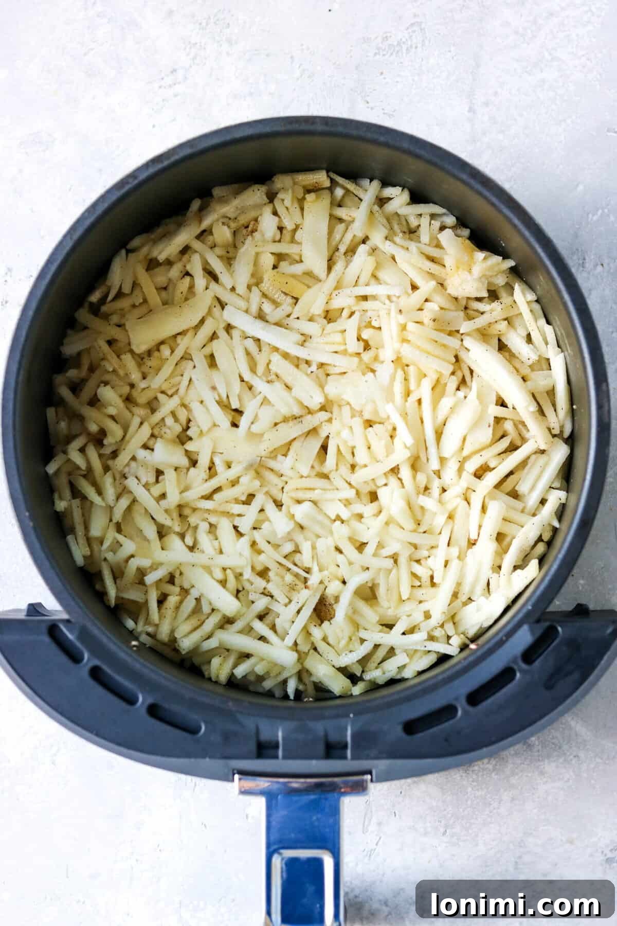frozen hash browns in an air fryer basket