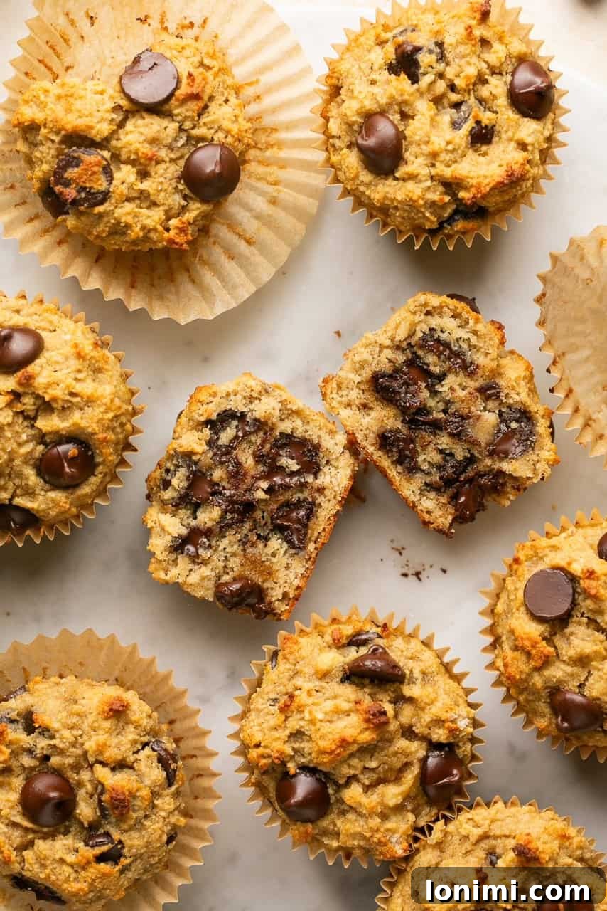 gluten free banana bread muffins with chocolate chips with one cut in half showing the gooey middle, highlighting the melted chocolate