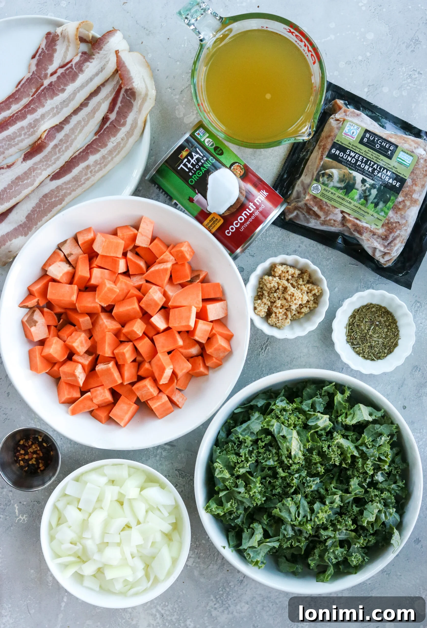 Hearty Whole30 Paleo Gluten Free Zuppa Toscana 3 Arrangement of fresh ingredients for Whole30 Zuppa Toscana including sausage, kale, sweet potatoes, and spices in small bowls