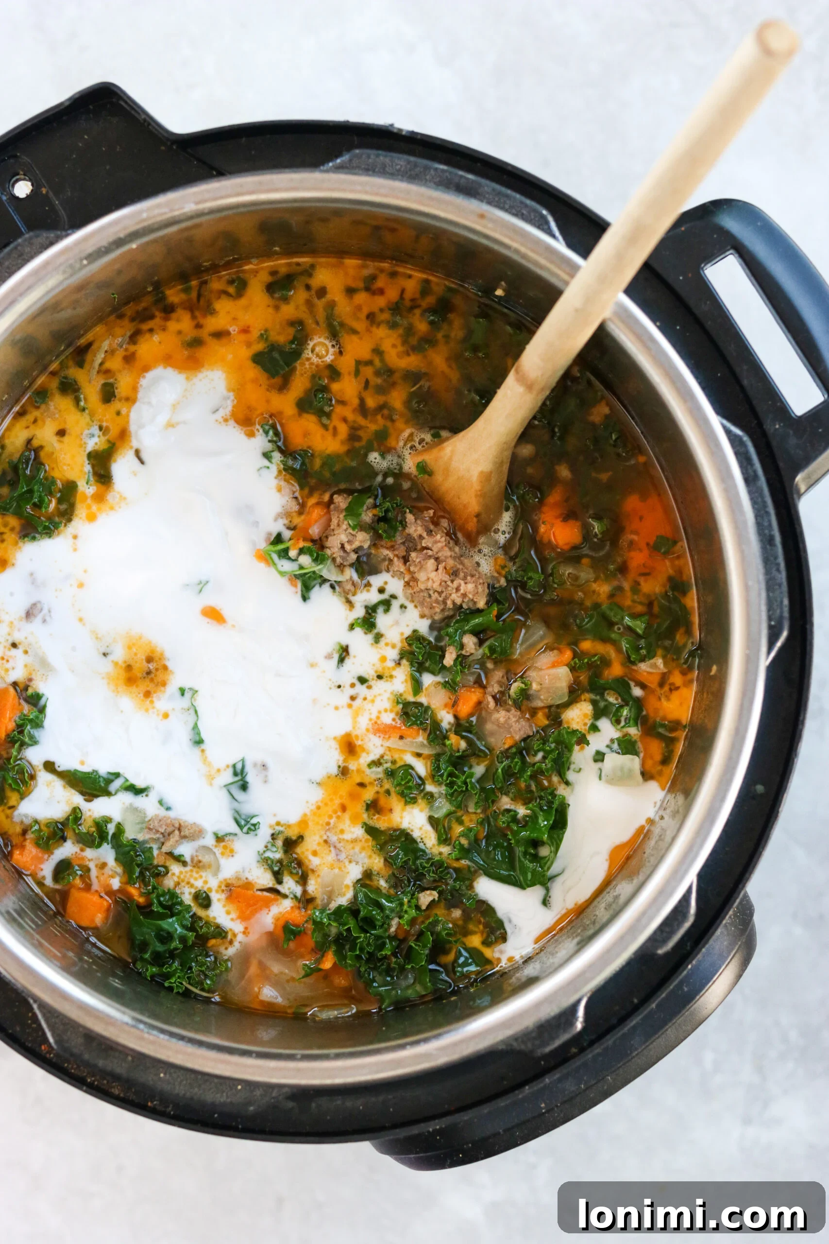Hearty Whole30 Paleo Gluten Free Zuppa Toscana 6 Adding rich, creamy coconut milk to the Instant Pot Zuppa Toscana, stirring it into the simmering soup