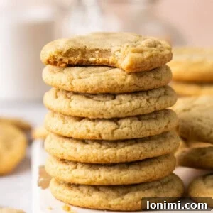 Chocolate chipless cookies stacked on a white piece of wood